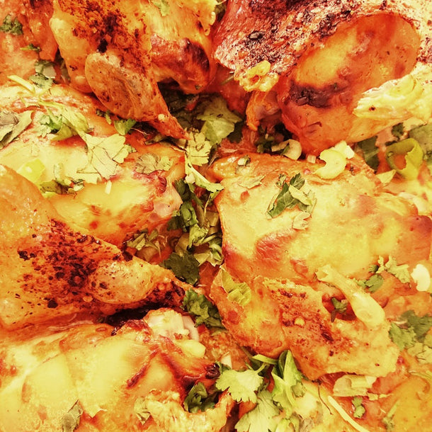 Crunchy skin chicken thighs roasted with harissa, garnished with fresh coriander