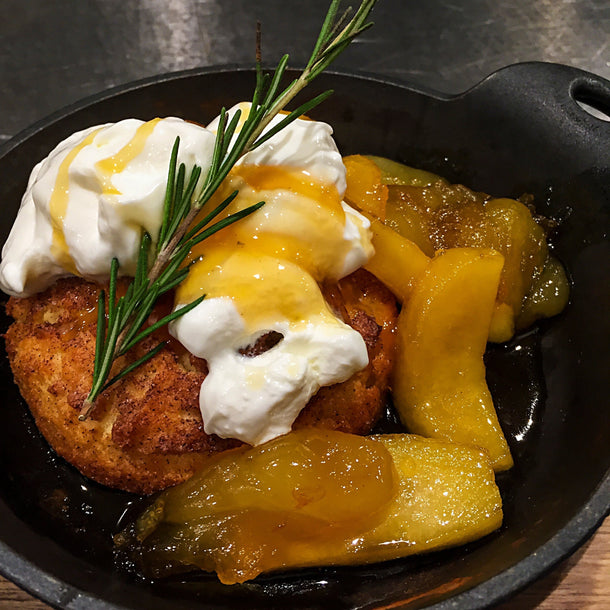 Spicy Cinnamon Apple Brown Butter Skillet Shortcakes served with a generous dollop of soured cream and a sprig of rosemary