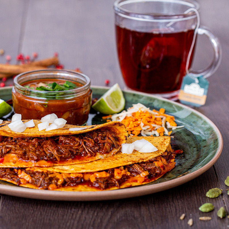 Birria tacos with soft tortillas filled with slow-cooked shredded beef, served with rich consommé for dipping.