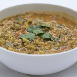 Bowl of hearty lentil curry garnished with fresh cilantro