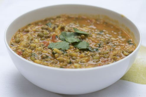Bowl of hearty lentil curry garnished with fresh cilantro