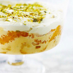 Trifle glass filled with enticing layers of decadent Bombay Gin trifle, scattered with crushed cardamom and pistachios
