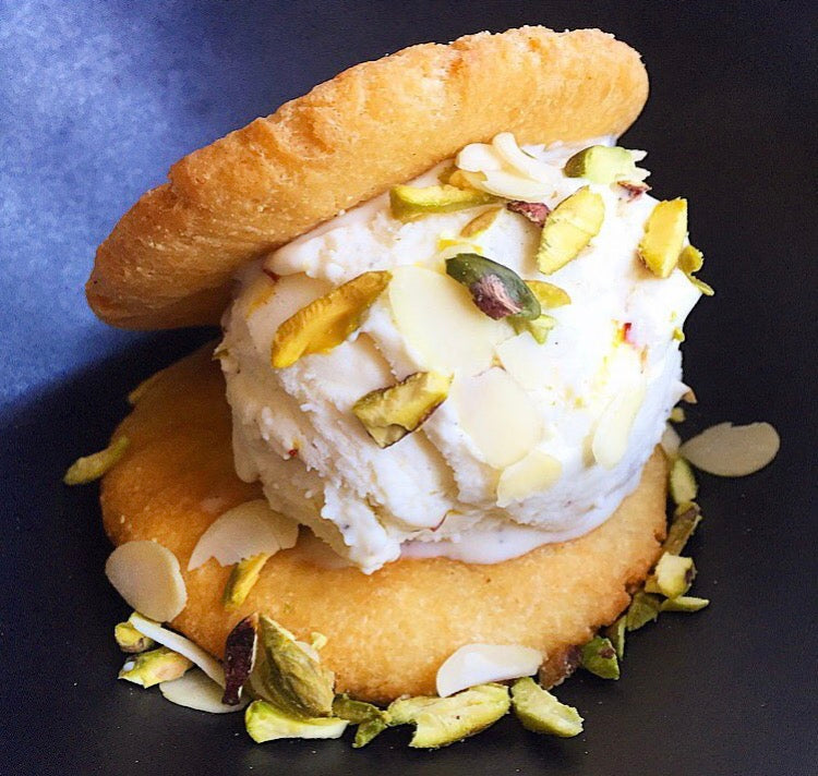Fluffy Shrikhand Ice Cream sprinkled with pistachios in between flaky, buttery puri