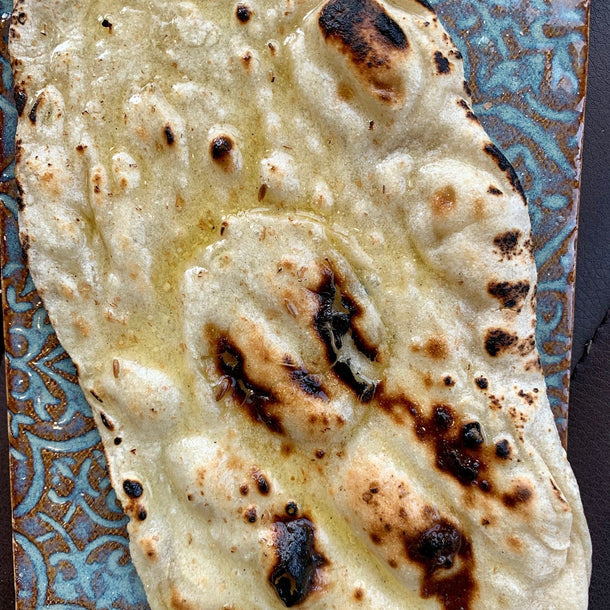 Soft flat bread, lightly cooked and golden, served warm with a tender, pliable texture.