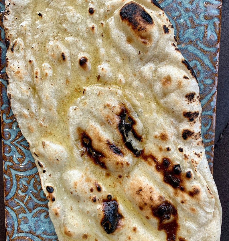 Soft flat bread, lightly cooked and golden, served warm with a tender, pliable texture.