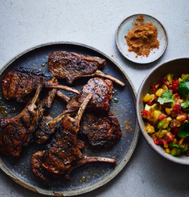 A plate of Succulent Jerk Lamb Chops served with a colourful Mango Salsa.
