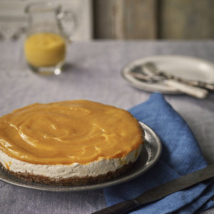 Mango shrikhand cheesecake- thick creamy yoghurt on a crunchy date and nut base, topped with fresh blended mango and served with a glass of mango juice