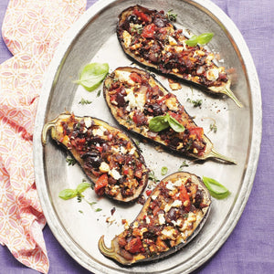 A serving platter of baked aubergines stuffed with tomatoes, Greek feta and black Kalamata olives