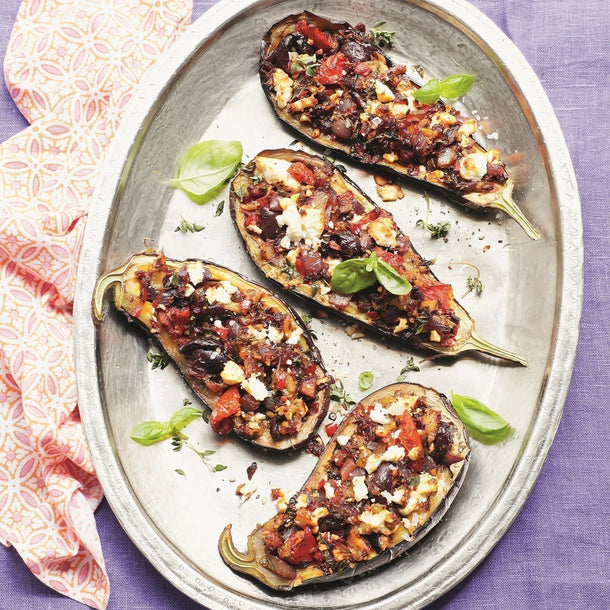 A serving platter of baked aubergines stuffed with tomatoes, Greek feta and black Kalamata olives