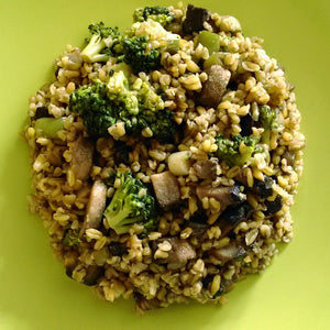 Mushroom and broccoli freekah served in a green bowl