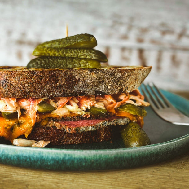 A Reuben-esque sandwich, made with coleslaw, pastrami and pickles