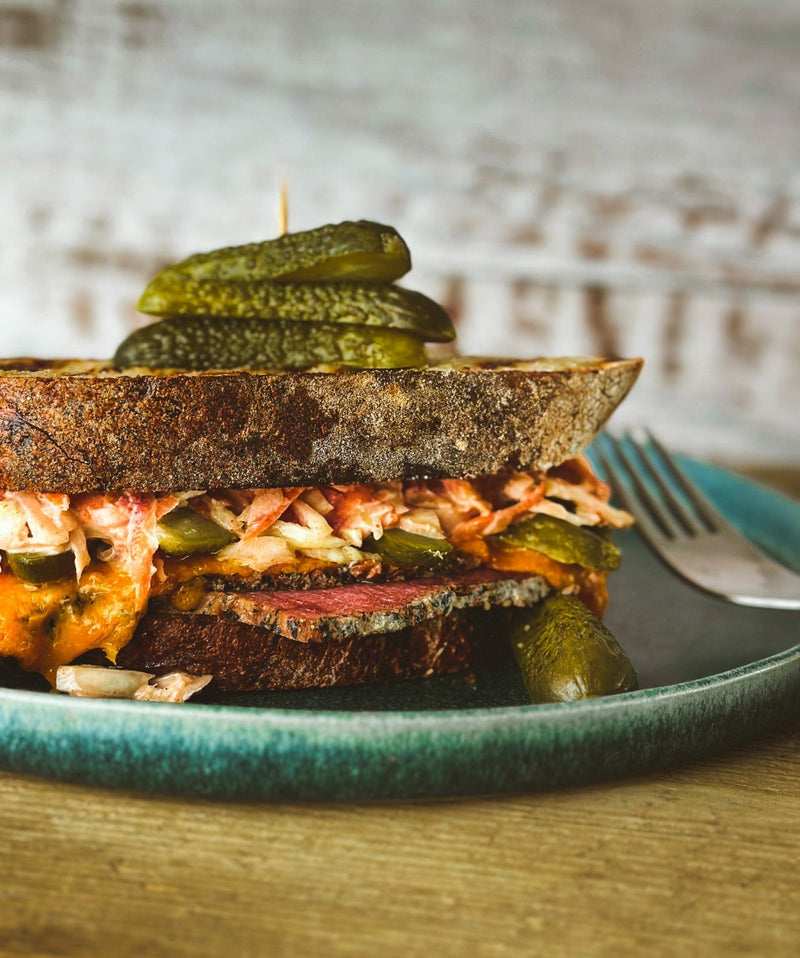 A Reuben-esque sandwich, made with coleslaw, pastrami and pickles