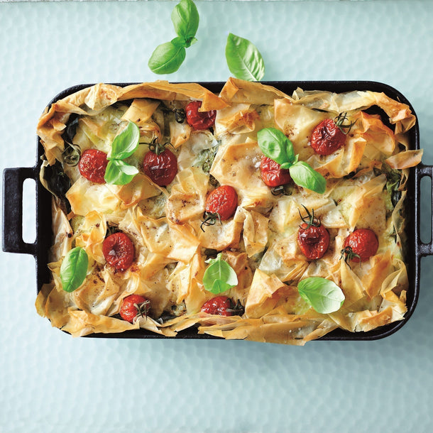 Garam Masala Bastilla topped with golden crispy filo pastry, cherry tomatoes and fresh basil leaves served in a rectangular baking dish