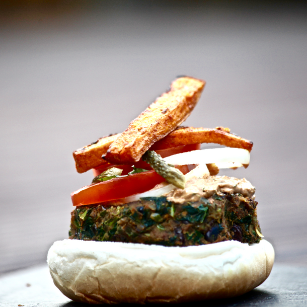 Vegetarian kale and masala burger, topped with sweet potato wedges and a healthy chipotle sauce