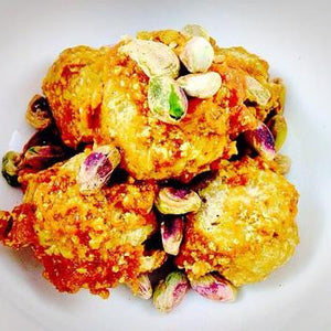 Golden pistachio dessert balls topped with crushed pistachios
