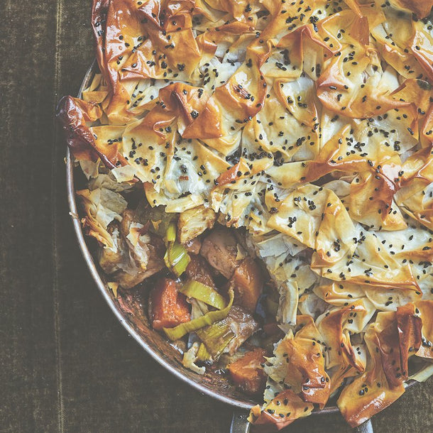A beautiful crispy-looking Tandoori-Spiced Celeriac Butternut Squash Pie with one Portion spooned out of it.
