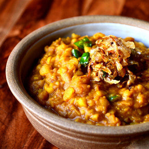 Traditional lentil dhal served in a rustic bowl with fried onions