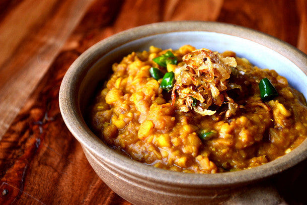 Traditional lentil dhal served in a rustic bowl with fried onions