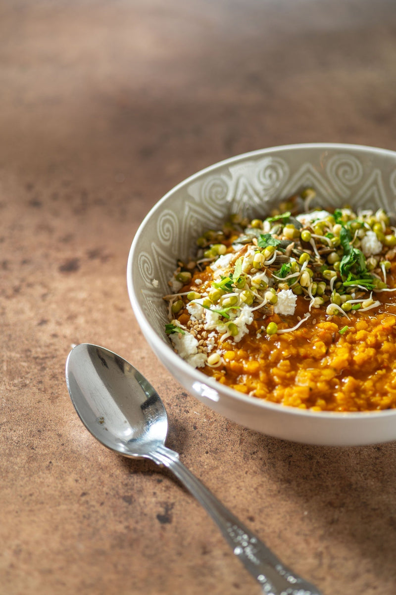 A bowl of Urvashi Roe’s Dhal, Garnished with Beansprouts.