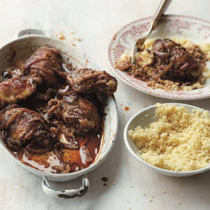 Juicy Baharat Spiced Chicken served in a banquet dish with a bowl of fluffy couscous on the side