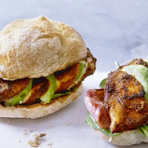 Fully loaded Cajun chicken burger with crispy spiced chicken, fresh salad, melted cheese, and creamy sauce in a soft bun.