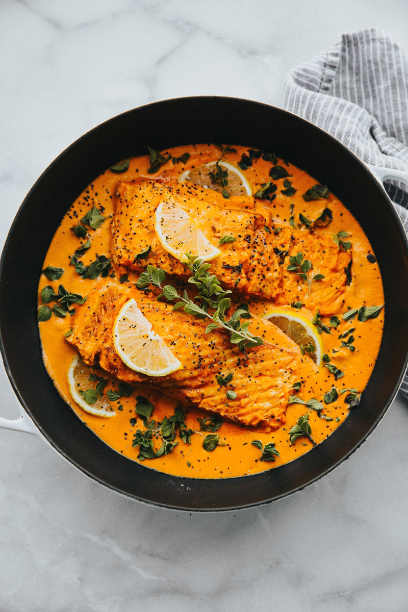 Salmon curry with tender salmon fillets simmered in a spiced coconut or tomato-based sauce, garnished with herbs.