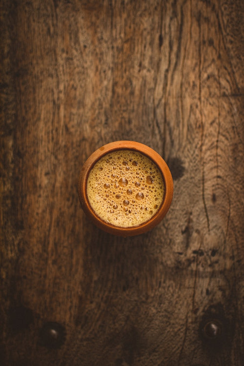 Traditional Indian chai served in a clay cup on wooden table