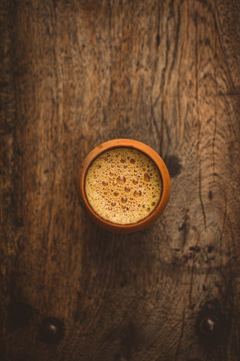 Traditional Indian chai served in a clay cup on wooden table