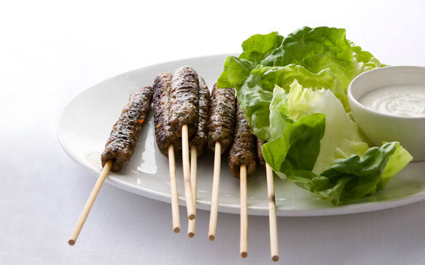 Spicy Middle Eastern kofte skewers served with lettuce and yogurt dip