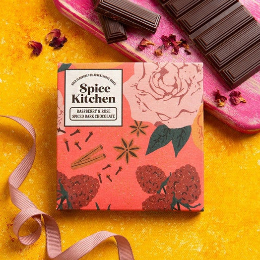 Spice Kitchen's Raspberry and Rose Spiced Dark Chocolate is displayed on a textured yellow surface. 