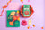 Spice Kitchen cookery book by Sanjay Aggarwal, and spice kit on a purple background with decorative elements