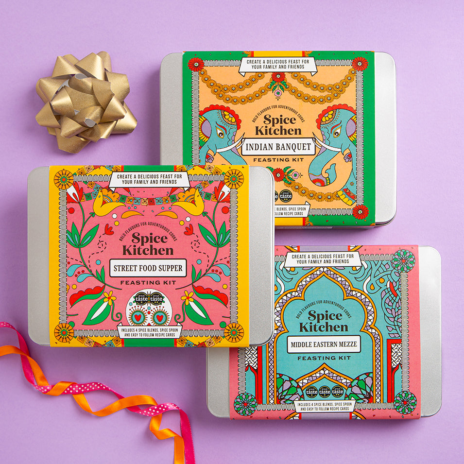 Three Spice Kitchen feasting kits on a purple background with decorative ribbons.