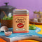 Spice Kitchen Italian spice blend tin on a colourful table with garlic and herbs scattered around.
