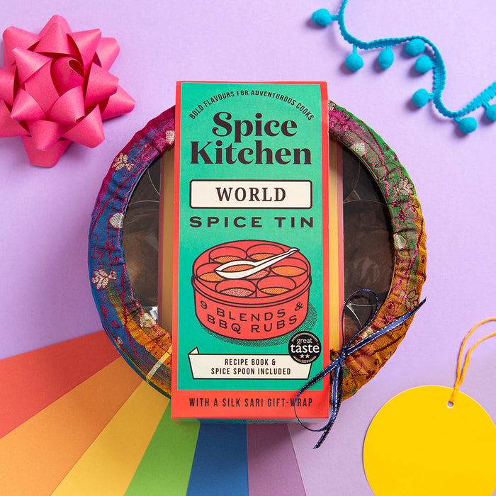 Spice Kitchen Pride Tin World Spice Tin on a colourful background with a pink bow and blue tassels.
