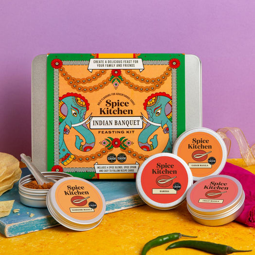 Spice Kitchen Indian Banquet kit with four award-winning spice blends on a yellow surface against a purple background