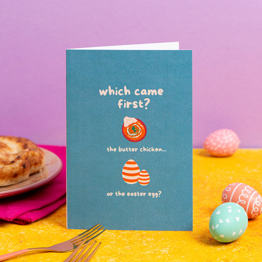 Card with Easter-themed question on a table with Easter eggs and a pie.