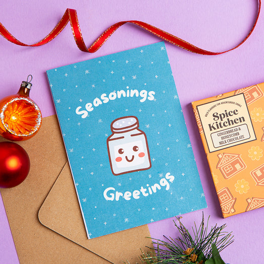 Festive greeting card with a spice jar illustration and text on a purple background with snowy decorations.