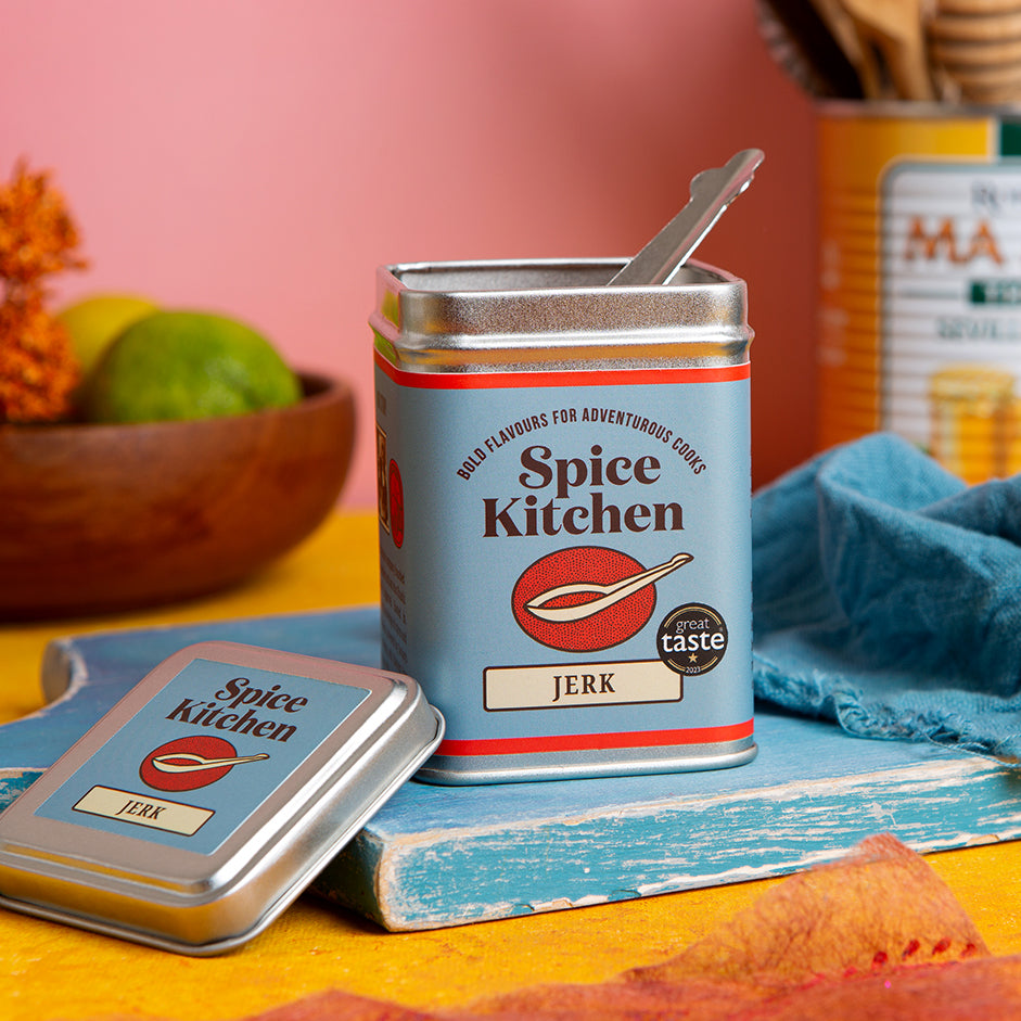 Spice Kitchen jerk seasoning can with a spoon on a colorful background